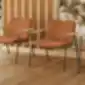 Dvi Xail XAI0030 poilsio kėdės iš INCLASS su šiltos rudos spalvos audiniu.